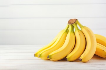 Ripe bananas on white wooden background