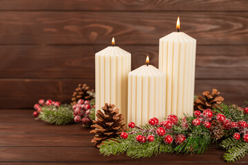 Christmas decoration with candle on texture background. New Year and Christmas candles. Cozy home decor. Burning candle and Christmas decoration. Christmas lights. Copy space.Holiday concept. 