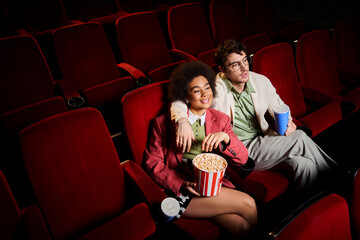 good looking joyful diverse couple in retro stylish attires watching movie on date at cinema