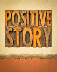 positive story word abstract in vintage wood type on art paper, good news or success concept