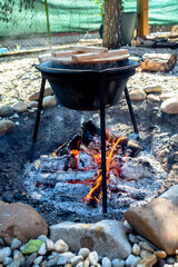 cooking traditional goulash boiling in a 12 liter cauldron outdoors - obrazy, fototapety, plakaty