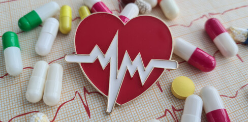 Cardiogram with red heart pills and cardiogram. Treatment of cardiovascular disea