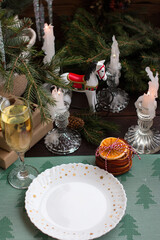 New Year's table setting with a glass of champagne. Preparations for the New Year and Christmas, Christmas tree and romantic candles