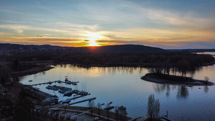 Boats and docks at dawn reflected on Lake Maggiore in Italy. Shades of colors in the shadow of the night