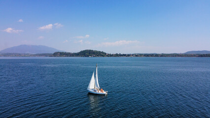 Sailing boat in Italy, Lombardia, Angera on the Lago Maggiore; In the background the mountains