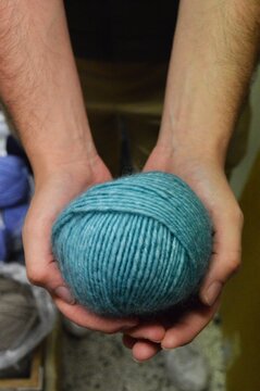 pelote de laine bleue et mains