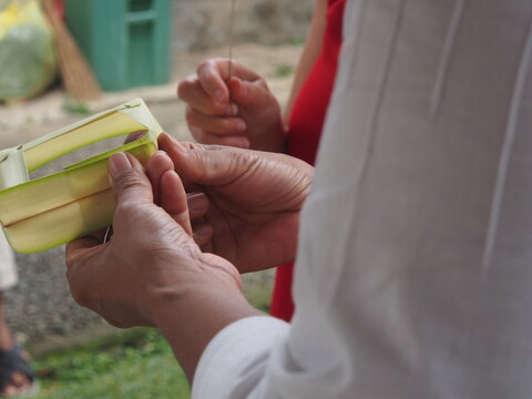 femme indon&eacute;sienne en train de confectionner un panier pour offrande