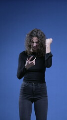 Woman pulling cellphone device and celebrates GREAT news on phone screen notification, standing on...