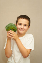 boy with broccoli over grey background