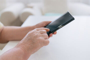 Crop woman using smartphone in living room