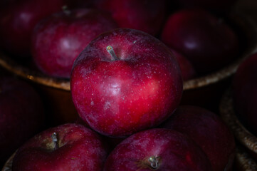 Red apples spilling out of a brown dish