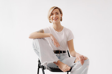 Bright and cheerful woman with a friendly smile, seated comfortably in casual attire, exuding a relaxed vibe