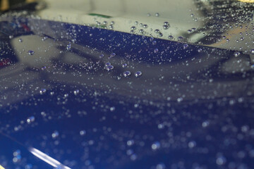 Man worker drying car on wash. Service car wash express. Worker uses turbo dryer to remove drops of...