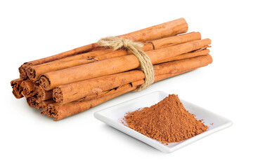 Cinnamon sticks with powder in ceramic bowl isolated on white background with full depth of field