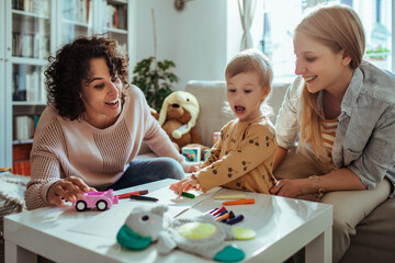 Lesbian couple playing with daughter at home