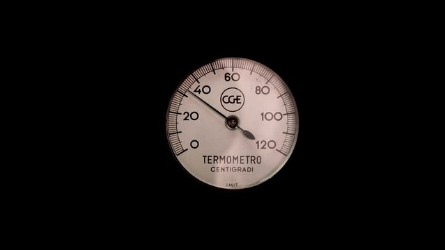 Old needle thermometer from 20 to 80 degrees, moving, black background.
