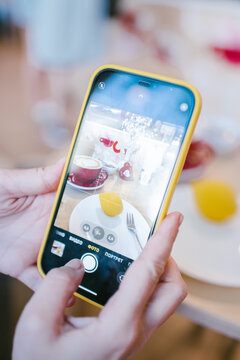 man takes pictures of beautiful food on his phone
