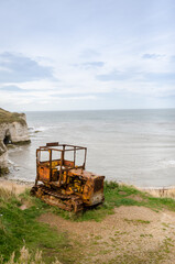 Fototapeta premium Aerial view of Flamborough North Landing, High Cliffs and sandy Beach, Flamborough, East Riding of Yorkshire, Jurassic coastline with abandoned tractor in a foreground