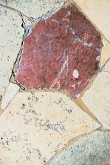 Bejahrter rot-beige-grauer Marmorboden mit Muster als Hintergrund