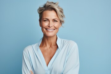 Portrait of happy middle aged woman with short blond hair smiling at camera - obrazy, fototapety, plakaty