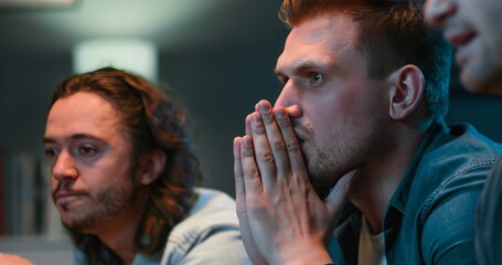 Close up of Caucasian guys sport fans sitting on sofa at home in front of TV and worrying for their favorite football team. Loosing in match concept. Dissapointment after lost in game.