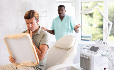Male client is dissatisfied with results of rejuvenating procedure at cosmetologist and...
