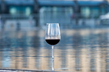 Tasting of Bordeaux blended red wine with wine city Bordeaux on background, left bank of Gironde...