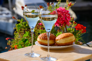 Drinking of French brut champagne sparkling wine with sweet apple Beignet, club party in yacht harbour of Port Grimaud near Saint-Tropez, French Riviera vacation, France