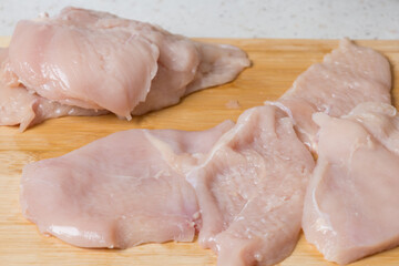 Raw meat - chicken breast on the kitchen table.