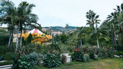 Scenic December view in Monaco, Carousel surrounded by lush greenery, set against the backdrop of...