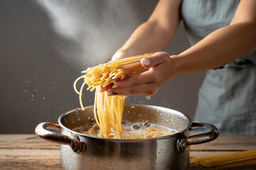 mettere la pasta nel acqua bollente chef cuoco  - obrazy, fototapety, plakaty