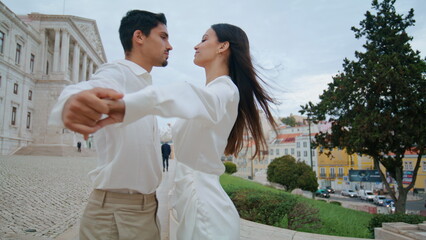 Fototapeta premium Happy lovers spinning street closeup. Latina couple holding hands laughing date