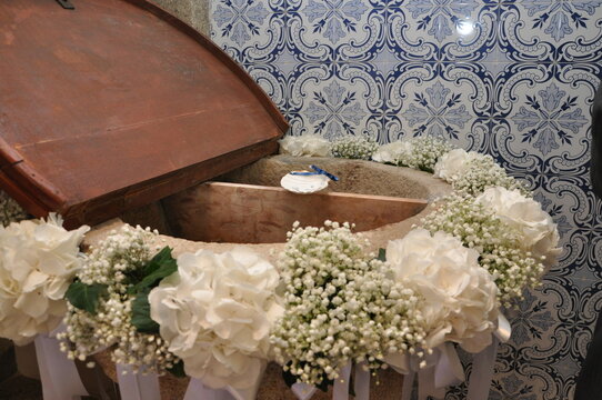 baptismal font in church decorated with flowers and shell