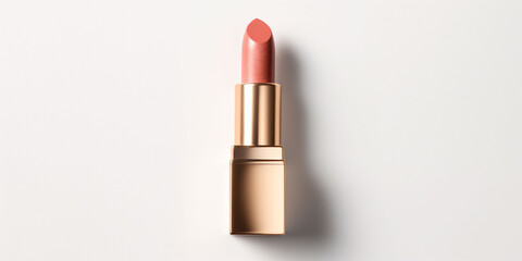 An peach fuzz color lipstick in a golden case on a white background. Make up a product show off. Copy space.