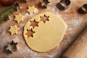 Rolled out pastry dough on a wooden board - preparation of Linzer Christmas cookies