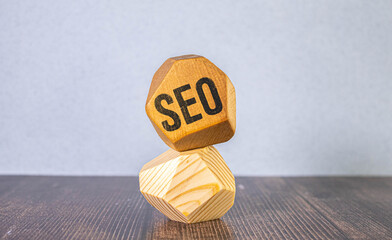 SEO - Search Engine Optimization symbol. Wooden blocks with words SEO. Businessman hand.
