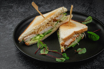 Sandwich with chicken meat, sauce, lettuce leaves