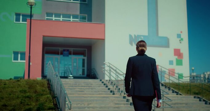 Sexy woman teacher going to school, rear view, following shot of lady in black suit, 4K, Prores