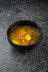 Traditional Russian and Ukrainian cuisine, appetizing chicken soup with egg on a dark background