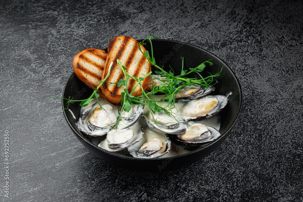 Poster Fried mussels with crouton in a dark plate