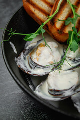 Fried mussels with crouton in a dark plate