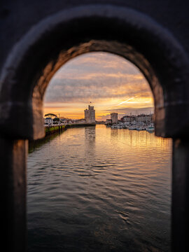view through balustrade of the old harbor of La Rochelle at blue hour with its famous old towers.