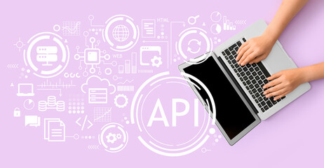 Female hands with laptop and virtual screen with abbreviation API on lilac background