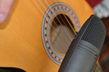 Acoustic guitar in front of microphone in living room