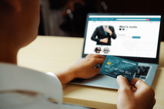 Young man use credit card for shopping payment online on laptop computer application or website. E-commerce and online shopping concept. uds