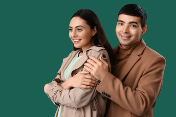 Young man hugging his girlfriend on green background