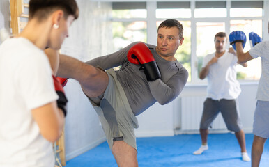 Kickboxing - an athlete kicks in sparring during training in the gym