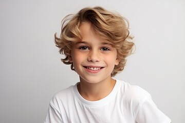 Portrait of a cute little boy with blond curly hair, studio shot - obrazy, fototapety, plakaty