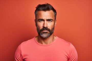 Portrait of a handsome man with beard and mustache on a red background.