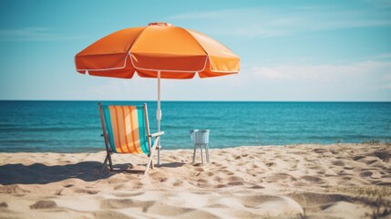 A beach chair and an umbrella on the beach.